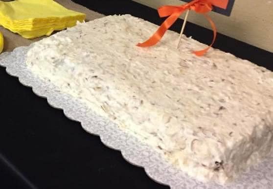 299790208_5320122608042149_2031301413228036566_n photo of cake with orange ribbon and yellow napkins